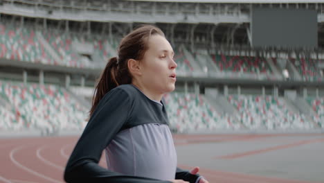 Porträt-Einer-Kaukasischen-Frau,-Die-Sich-Vor-Einem-Lauf-Am-Frühen-Morgen-Auf-Einer-Leeren-Stadionstrecke-Aufwärmt.-Aufgenommen-Mit-Einem-Anamorphotischen-Objektiv